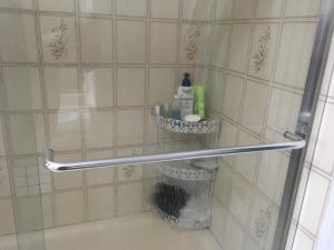 a bathroom with a shower with a towel rack and a toilet at Sandy's House in Vancouver