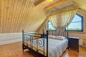 a bedroom with a bed and a large window at Country house Stirnamis in Mindūnai