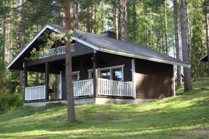 a cabin in the woods with a large porch at Koivurannan Lomamökit Mänty in Nykälä +13 photos