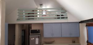 a kitchen with white cabinets and a staircase at Flamingo Cottage no 12 in Meersig
