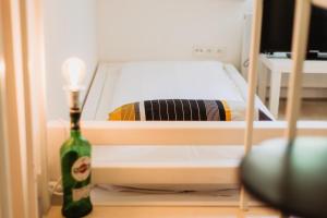 a small bed in a room with a bottle of wine at Street Food Possonium Apartments in Bratislava