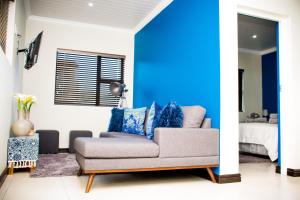 uma sala de estar com um sofá e uma parede azul em Camello em George