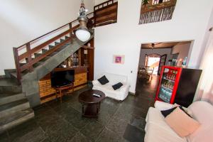 uma sala de estar com um sofá e uma televisão em Social Ilha Grande Hostel em Abraão