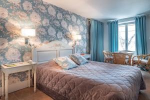 a bedroom with a bed and a painting on the wall at Auberge Du Lac in Saint-Marcel-lès-Annonay