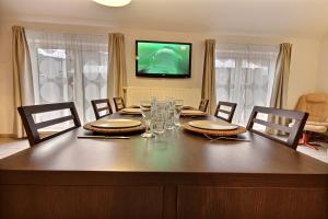 a dining room table with chairs and a television at Thier à Liege - hauts-sart in Liège