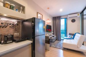 a kitchen with a refrigerator and a living room at Bangtao,Layan beach apartment in Bang Tao Beach
