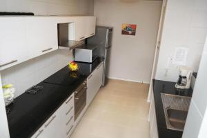 a kitchen with a black counter top and a refrigerator at Vega Apartment for Rent in Quito