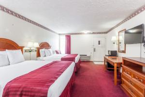 a hotel room with two beds and a flat screen tv at Knights Inn Hurricane Mills in Hurricane Mills