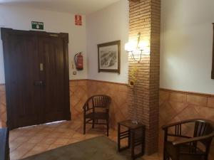Porcuna的住宿－Hospedería Ana Pilar，客厅配有两把椅子和一扇门