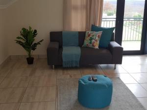 a living room with a couch and a blue ottoman at The Living Collective - The Gates in Hilton
