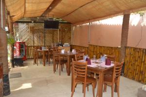 uma sala de jantar com mesas e cadeiras de madeira em Hotel Thilon em Katunayaka