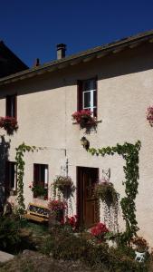 a white house with flower boxes on the windows at Cottage in Auvergne in Laval-sur-Doulon