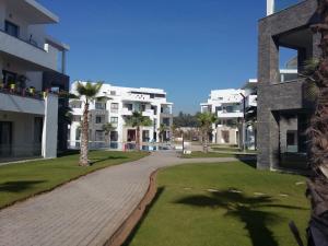 a walkway between two apartment buildings with palm trees at résidence hivernage, couples mariés in Agadir