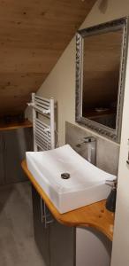 uma casa de banho com um lavatório branco e um espelho. em Auszeithütte em Flattnitz