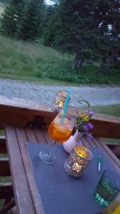a drink on a table on a wooden bench at Auszeithütte in Flattnitz