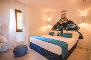 una camera da letto con un grande letto con un costume sopra di Geco di Giada Art Suites - Adult Only a Porto Rotondo