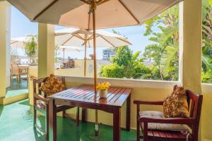 a table and chairs with an umbrella on a porch at Stadium Guest House in Cape Town