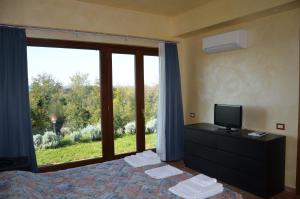 a bedroom with a bed with a television and a window at Francalancia Country Resort in Castelnuovo di Porto