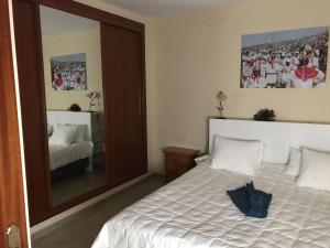 ein Schlafzimmer mit einem Bett und einem großen Spiegel in der Unterkunft VV Calle La Ola in La Restinga