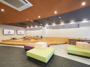 a lobby with a waiting room with tables and chairs at THE POCKET HOTEL Kyoto Shijo Karasuma in Kyoto
