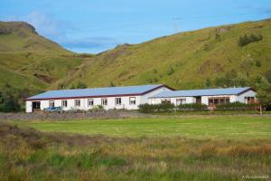 un edificio bianco con una collina sullo sfondo di Hótel Búrfell a Vík Altre 23 foto