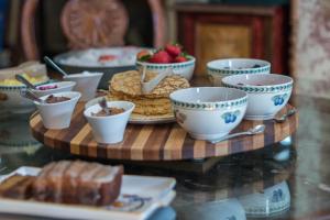a table topped with cups and plates of food at The Victoria Bed & Breakfast in Bentonville