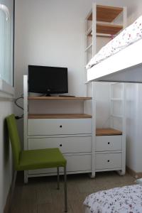 1 dormitorio con vestidor, TV y cama en Hotel Marco en Lido di Savio