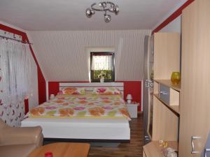 sypialnia z łóżkiem i czerwoną ścianą w obiekcie Ferienwohnung Hesse am Wachberg (Berghütte) w mieście Saupsdorf