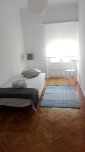 een slaapkamer met 2 bedden en een houten vloer bij Golden Apartment City Center in Lissabon