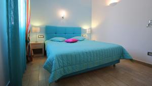 a bedroom with a blue bed with a pink pillow at Efharis in Kamares