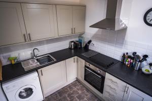 a kitchen with white cabinets and a black counter top at Douglas Apartment in Alexandria