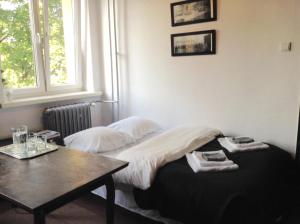 クラクフにあるAbsolutely Apartmentのベッド、テーブル、窓が備わる客室です。