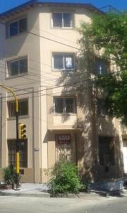 un edificio en la esquina de una calle con un semáforo en Departamentos céntricos en Zarate en Zárate