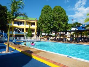 a large swimming pool with people in the water at Hotel Campestre Villa Yudy in Melgar