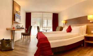 Habitación de hotel con cama grande y escritorio. en Therme 51° Hotel Physio & Spa, en Leukerbad