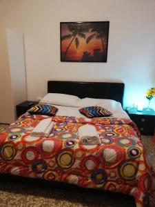a bed with a colorful comforter with two phones on it at Venice Best Vacation in Marghera