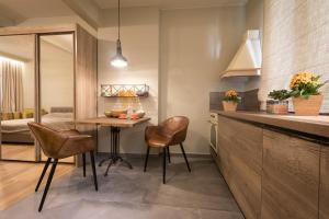 a kitchen with a table and chairs in a room at Este Apart - Top center in Sofia