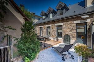 a patio with chairs and a christmas tree next to a building at Le Cosy de Claire in La Bourboule