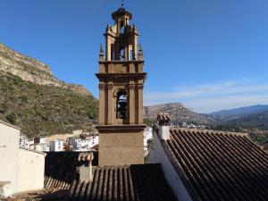 a clock tower on the roof of a building at La Muralla Del Castillo in Chulilla