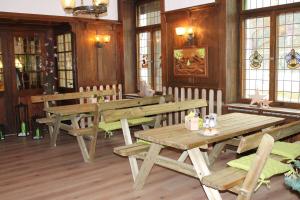 ein Restaurant mit Holztischen und -bänken und Fenstern in der Unterkunft Action Forest Hotel - Kletterwald - Lasertag - nähe Badeparadies in Titisee-Neustadt