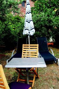 een tafel en twee stoelen met een paraplu bij La goutte d'or in Roussillon
