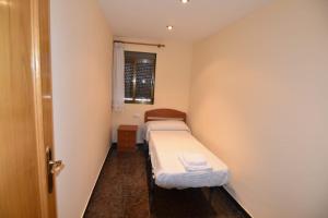 チュリリャにあるLa Muralla Del Castilloのベッド2台と窓が備わる小さな客室です。