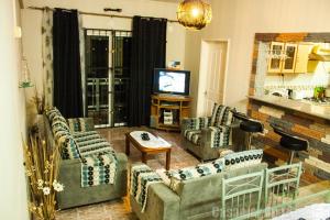 a living room with couches and a tv in it at Casanier Apartment in Pereybere
