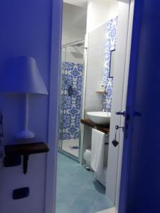 a blue bathroom with a sink and a shower at Hill Valley View in Vico Equense