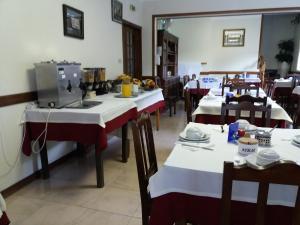um restaurante com várias mesas com mesas brancas e vermelhas em Horizonte do Geres no Gerês