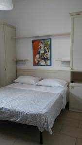 1 dormitorio con 1 cama y una pintura en la pared en B&B Stelle Della Daunia, en San Severo