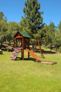 un parque infantil con tobogán y cenador en Cabañas Kumé Kintú en El Bolsón