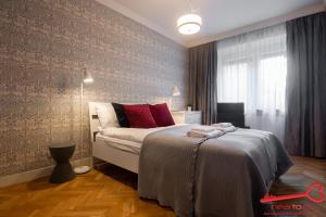 a bedroom with a bed with red pillows on it at Apartment Nearto Old Town Daszyńskiego street in Krakow