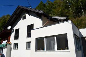a white house with black shuttered windows at Appartement Schmidl in Flattach