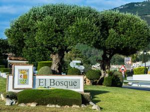 un signe devant un signe avec un arbre dans l'établissement Apartamentos Casa Gil, à El Bosque